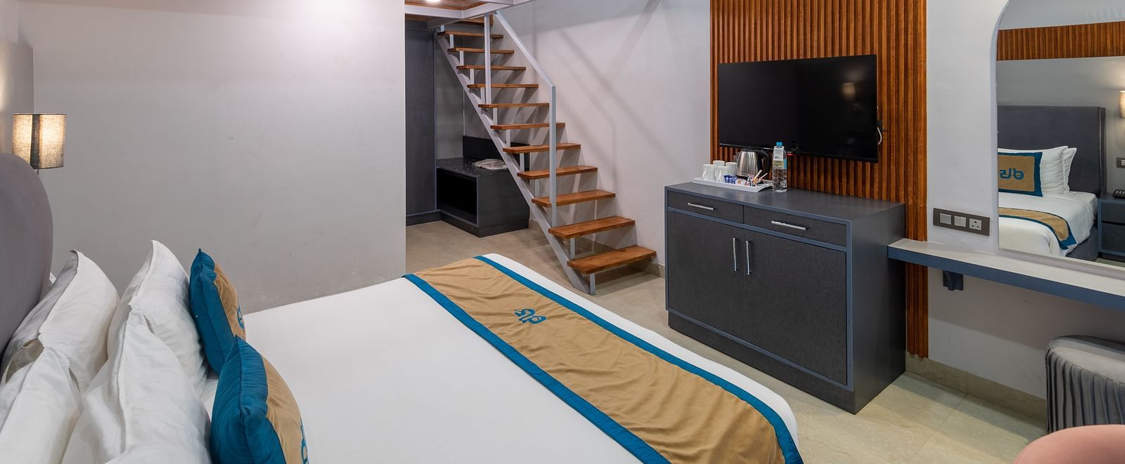 Spring Duplex Room at DLS Spring  Valley resort Dharamshala featuring a king bed table, chairs and stairs leading to second story